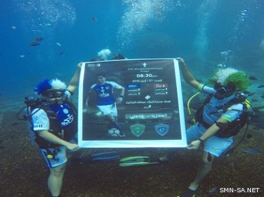 مشجعون يحملون بطاقة لقاء الهلال والأهلي داخل أعماق البحار